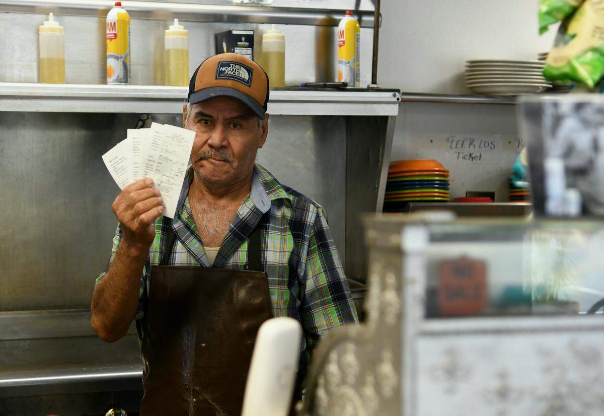 ReFujio Rosas, an employee at Ray’s Cafe on Northridge Drive holds up four receipts for to go orders on the morning of Wednesday March 18, 2020 on Hilton Head Island. “People come in and I tell them only to go orders and they turn around and leave,” a waitress said who chose not to give her name. Wednesday marked the first day after SC Gov Henry McMaster ordered restaurants and bars closed for sit down guests.