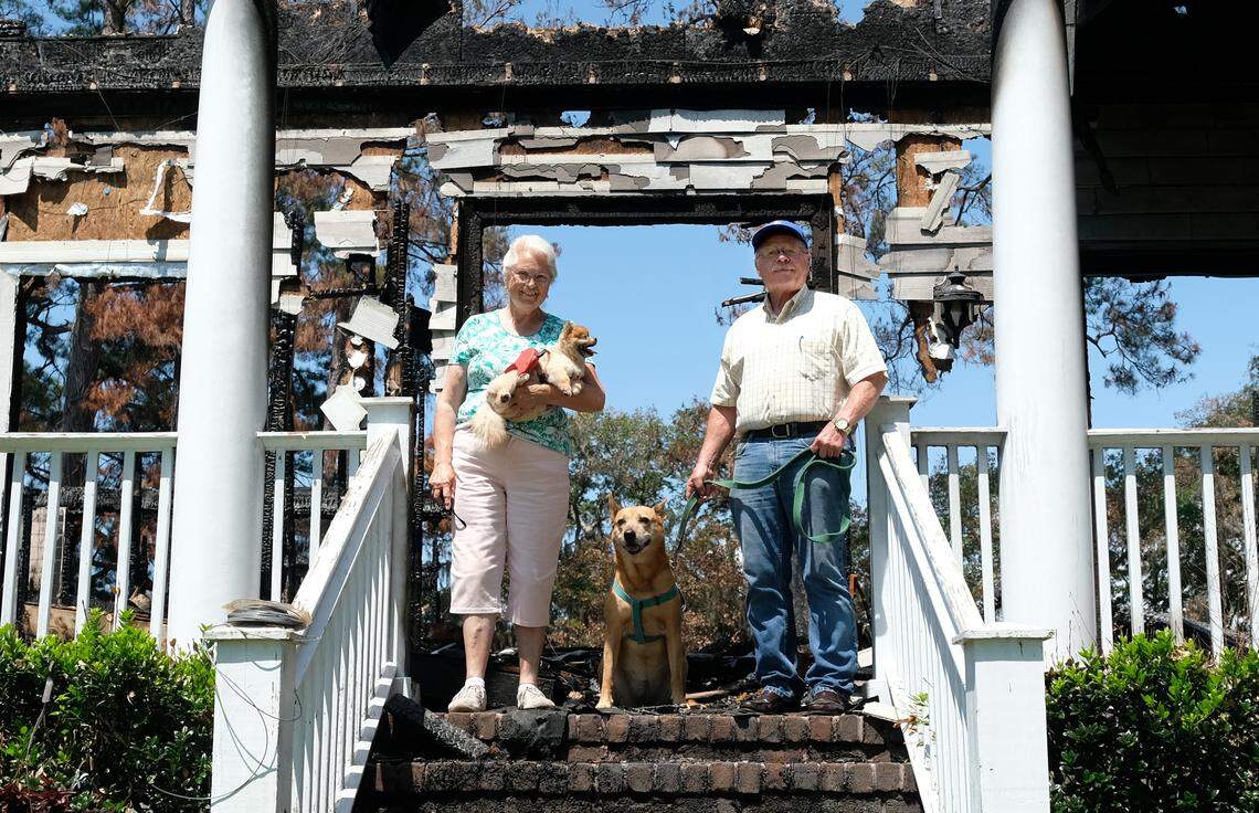 Helen Rivers, holding Angel, and her hsuband Thayer Rivers, leashed with Trixie, stand for a portrait on Thursday, June 14, 2018 at their Seabrook house that was destroyed by a fire about a month prior. The two dogs pictured were with Helen on a walk when the six-bedroom home was burned to the ground about a month prior. A family friend who was in the house when the fire started made it out of the house safely but two dogs, a puppy and a husky-mix, were killed in the fire. Thayer, who arrived to the home after his wife called said, “I hate it about the two little dogs (that were killed),” but was appreciative there were no human fatalities.