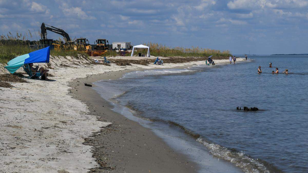 People enjoy the beach at Fish Haul Beach Park on Aug. 15, 2025, as machinery for renourishing the beach looms in the background. According to the Town of Hilton Head Island, work is expected to start the first week of September and will be closed to the public for about five days.