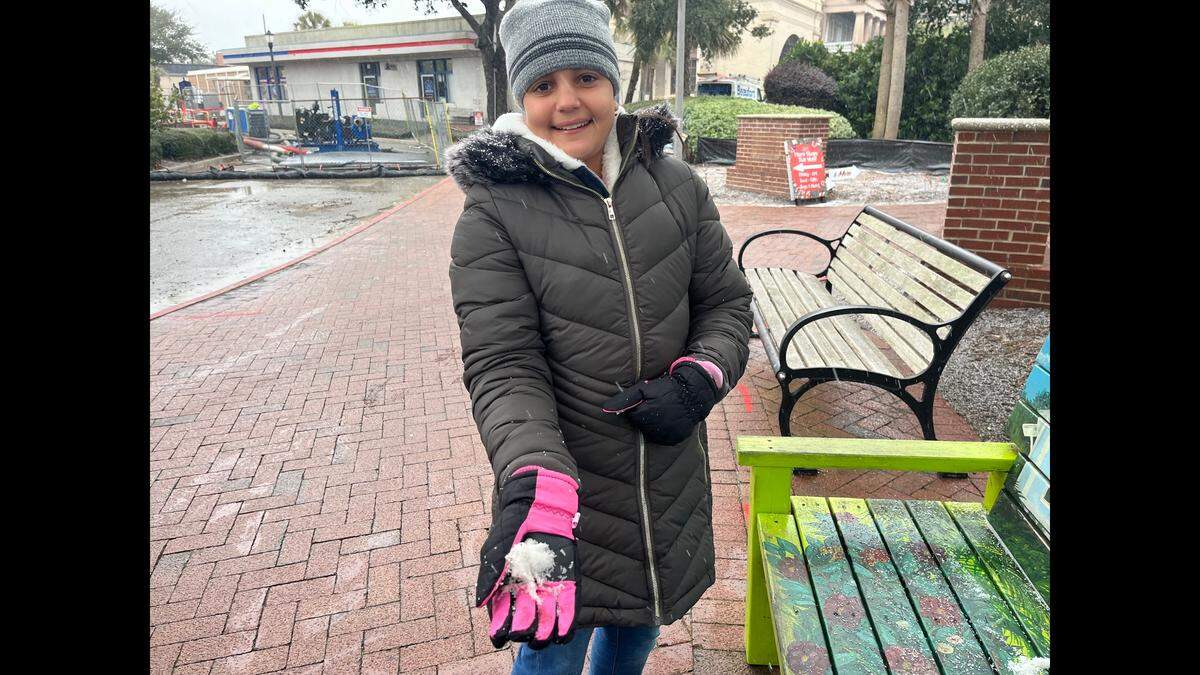 Gabriela Almeyda tries to form a snowball at Beaufort Waterfront Park soon after the skies began spitting a wintry mix at about 2:30 p.m. Saturday. It was the first time the visiting Florida girl had seen snow. “It’s soft,” she said.