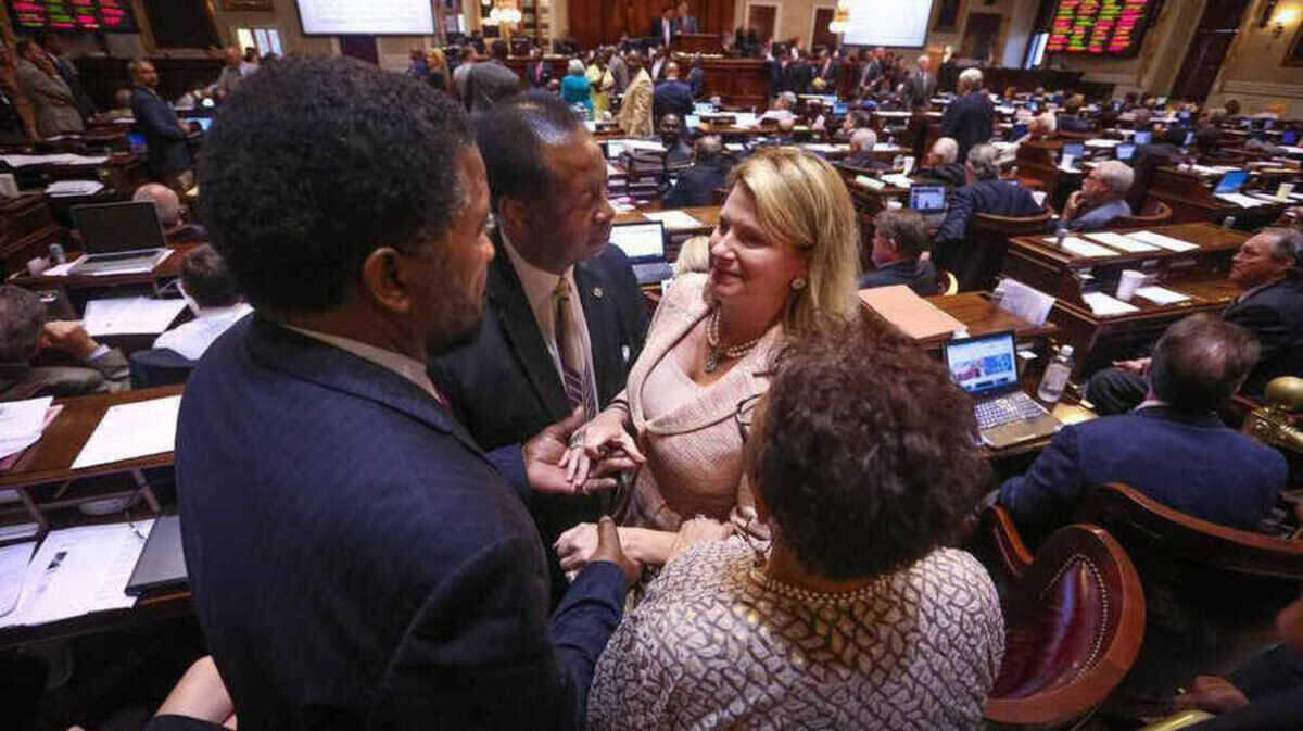 FILE: Rep. Jenny Horne, R-Dorchester, is congratulated by Reps. Karl Anderson, Wendell G. Gilliard and Pat Henegan after her impassioned plea to the House members to remember the nine people who were killed in Charleston on June 17, 2015, during debate in the SC House of Representatives on a bill that would remove the Confederate flag from the State House grounds. The bill passed in the early morning hours of July 9.
