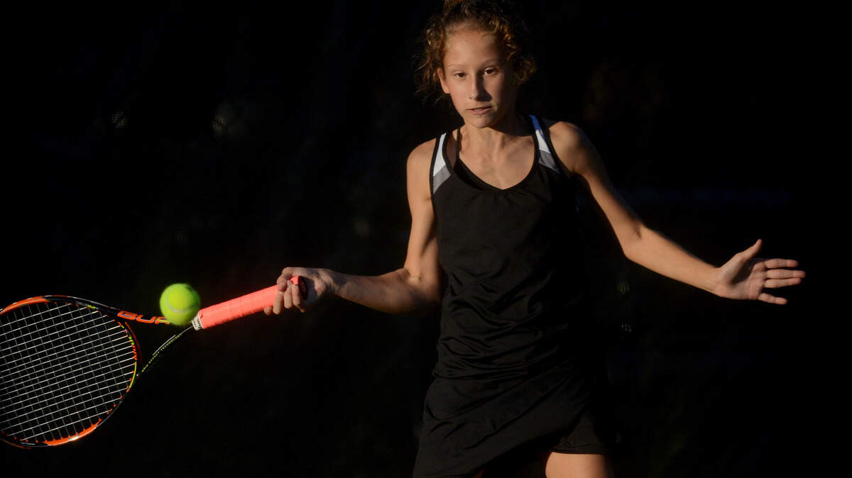 Bluffton?s Natalie Bassett swings to hit the ball back to her opponent on Tuesday night during Bluffton?s Class 4-A girls tennis lower state final against Wando at Bluffton High School.