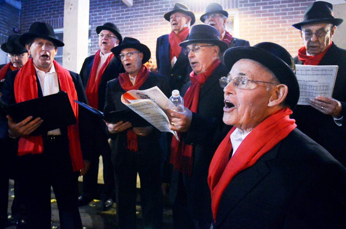 Hal McCann, foreground, and the rest of the Beaufort Harbourmasters Lowcountry Barbershop Chorus sing carols in downtown Beaufort at the 2014 A Night on the Town. 