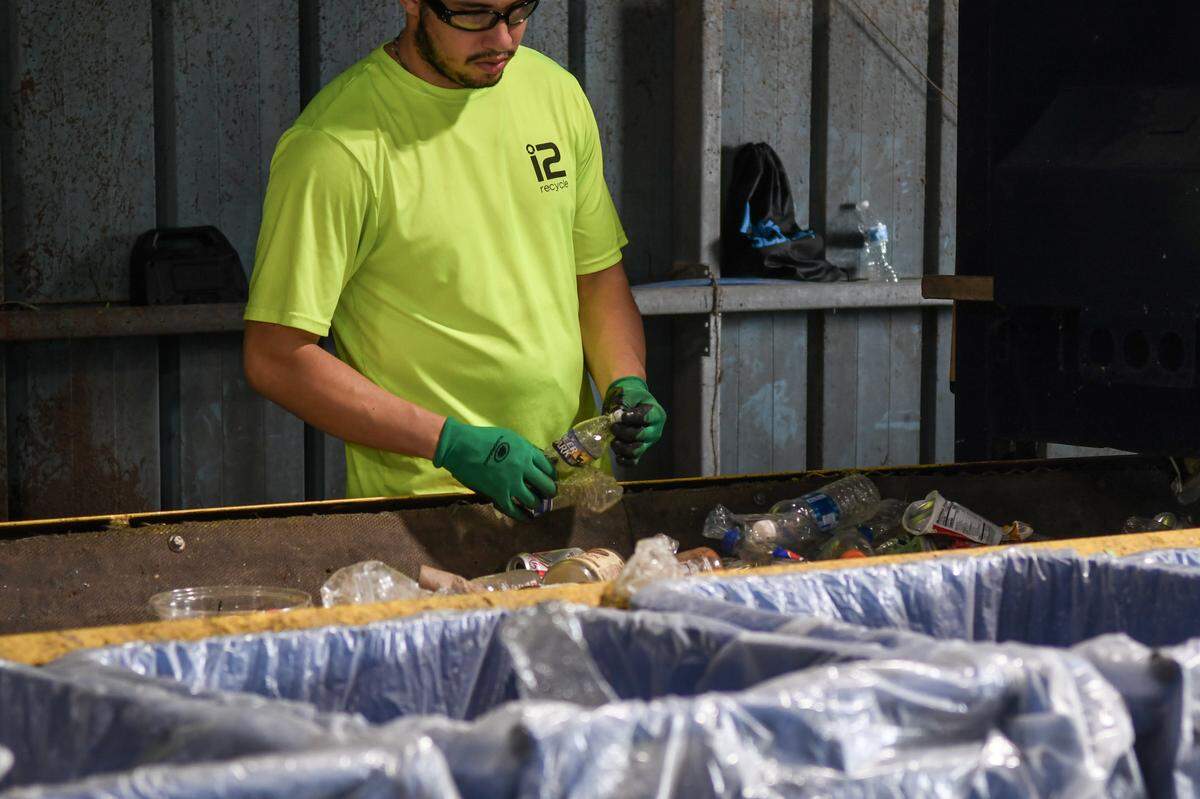 Workers must remove the caps to plastic bottles in order for the machine to properly compress the bottles into bundles to be sold as photographed on July 12, 2024 at i2recycle located in the Hardeeville Industrial Park in Hardeeville, S.C. Bennett says the lids make some bottles so strong they don’t pop when compressed into bundles.