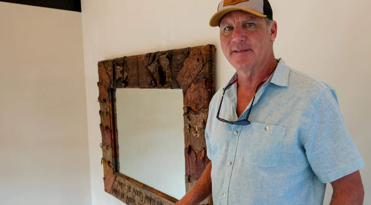 Jerry Leonard, owner of The Smokehouse on Hilton Head Island, stands on the stairs to the restaurant’s future rooftop deck on Tuesday, Aug. 24, 2021. A mirror that survived the June 9, 2019, fire hangs behind him. Leonard said the mirror was located on the other side of the former restaurant away from the ignition point. “That’s how hot the fire was.” he said, noting the melted boot leather at the top of the piece.