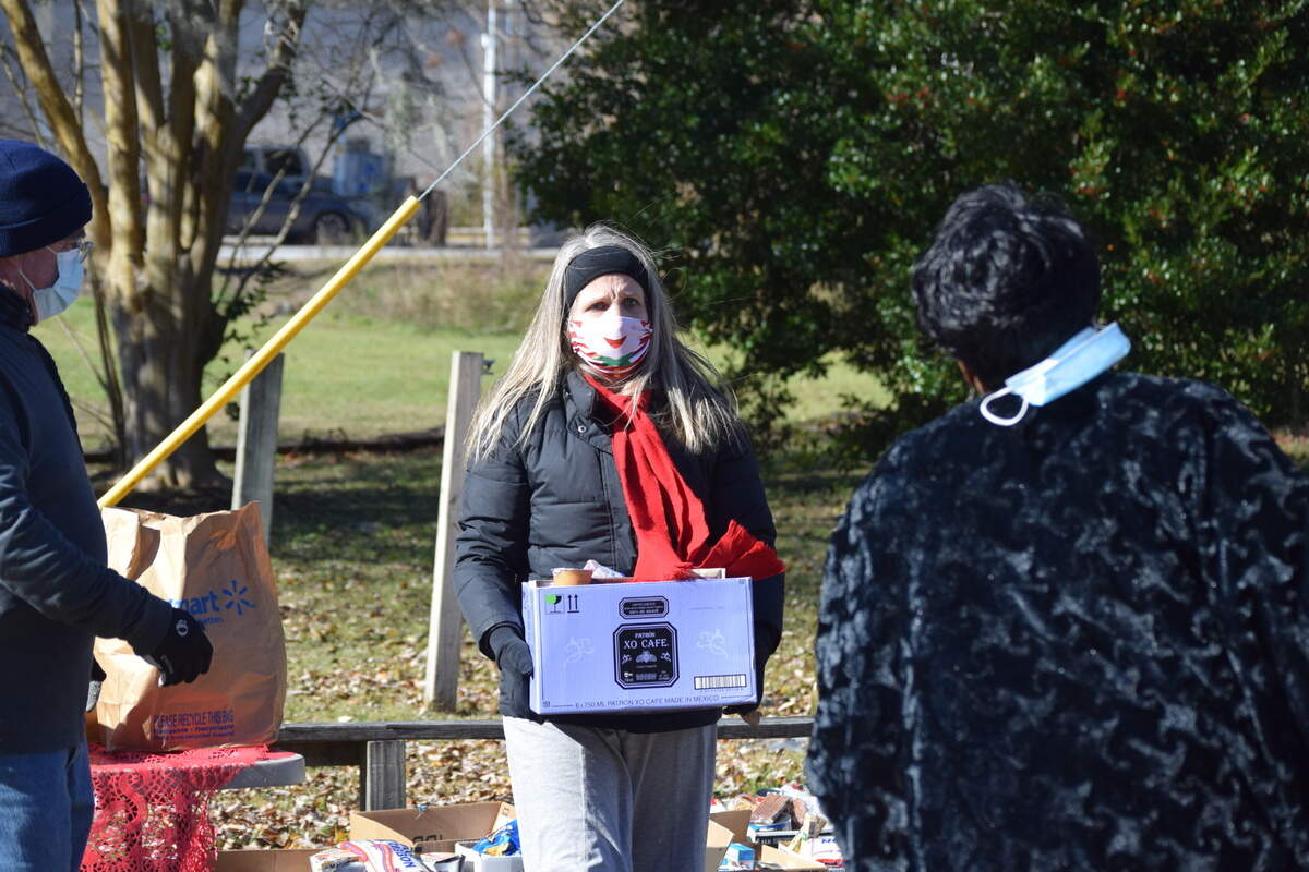 Tanya Gault, 46, carries a box of nonperishable food during a Christmas meals event on St. Helena Island on Friday, Dec. 25, 2020.