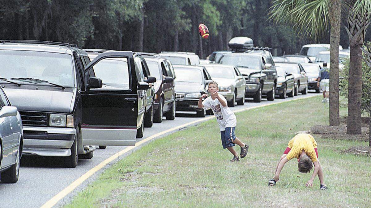 In this file photo taken during the Hurricane Floyd evacuation on  Sept. 14, 1999, brothers Tyler, left, and Brock McHenry, of Alliance,  Ohio, play football in the median of William Hilton Parkway near Union  Cemetery Road, while waiting with their family for traffic to begin  moving.