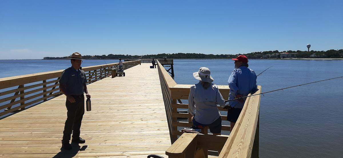Ranger Brandon Goff speaks to Brian and Mary Lou Gilfedder of Beaufort on the Hunting Island State Park fishing pier Thursday. The pier has reopened after major work to fix repairs caused by Hurricane Matthew. “They come out, wet a line and make memories out here,” Goff says of visitors to the popular pier.