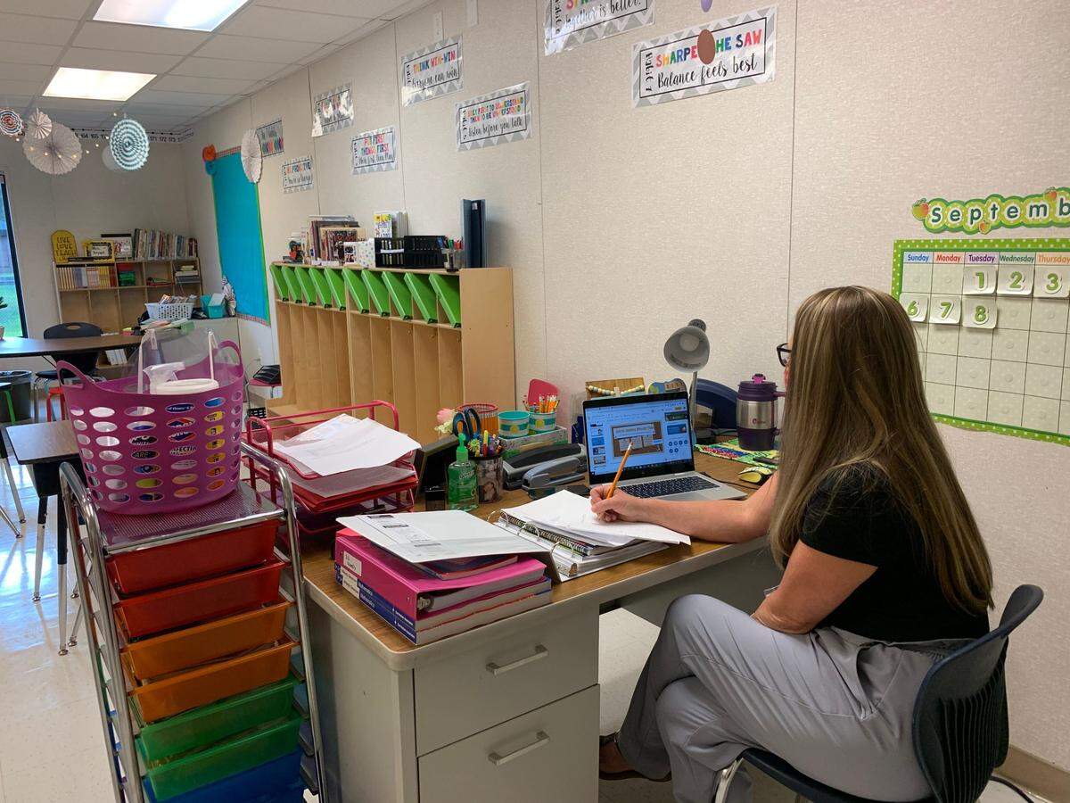 April Bryant, a fifth grade teacher at Coosa Elementary School, answers technology questions students have minutes before the first day of virtual instruction for the 2020-21 school year begins. Bryant is one of a number of teachers who chose to go into the school buildings to do their work.