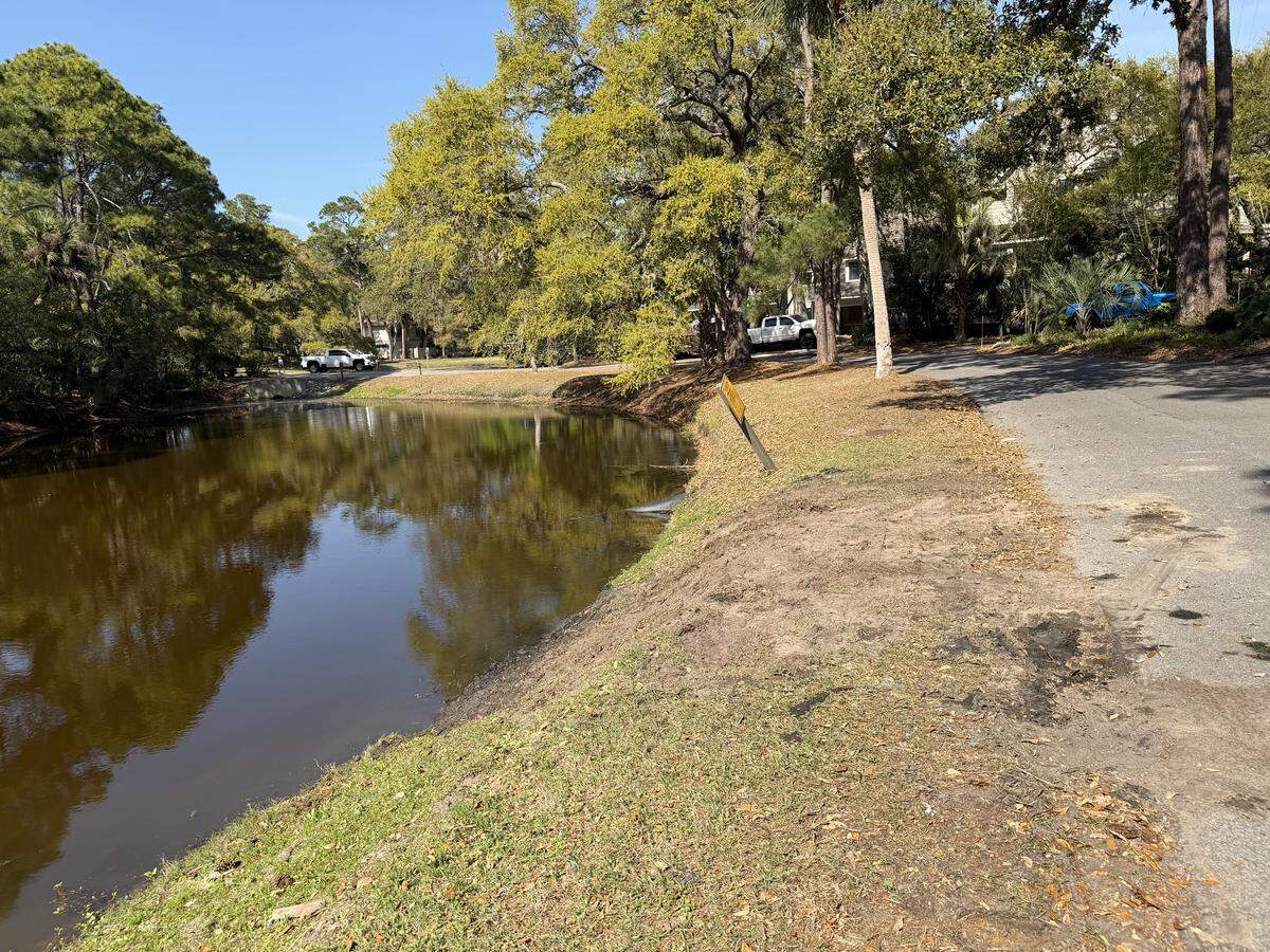 The grassy slope was torn up alongside South Beach Lagoon Road on April 1, 2026, after authorities removed a Lincoln SUV that had slipped into the water within Hilton Head Island’s Sea Pines gated community. Most homes and roadways are bordered by lagoons in the Beach Lagoon neighborhood.