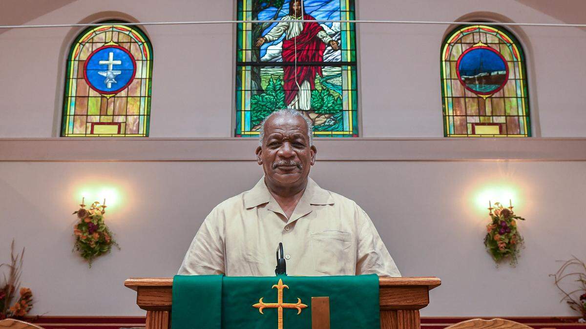 The Rev. Edward B. Alston of Hilton Head Island’s Queen Chapel AME Church will be retiring after serving as pastor for 29 years. Behind him, stained glass — separated by Jesus Christ — simplifies the story of the church. At left, an anvil and cross symbolizes a blacksmith shop, the meeting place for the first AME church. At right, the steamship “Arago” which landed on Hilton Head in 1865 due to a storm, bringing two AME ministers en route to Charleston to Mitchelville, where they held a service and established roots for what would become Queen Chapel AME.