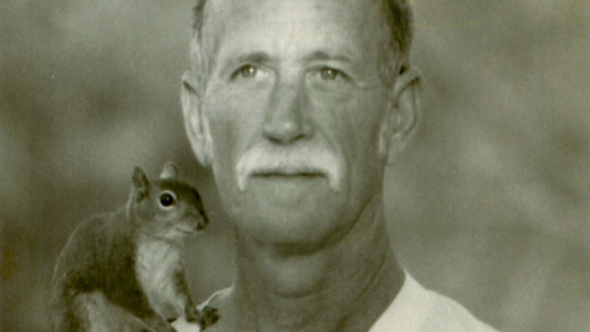 Peppy, a squirrel raised by the family, sits on Harry’s shoulder waiting on a nut.