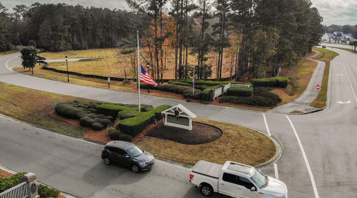 Behind a tree lined buffer fronting Buckwalter Parkway at the entrance to Woodbridge as seen on Dec. 8, 2021 sits a cleared plot of land for the May River Marketplace - a marketplace and music venue - in Bluffton.