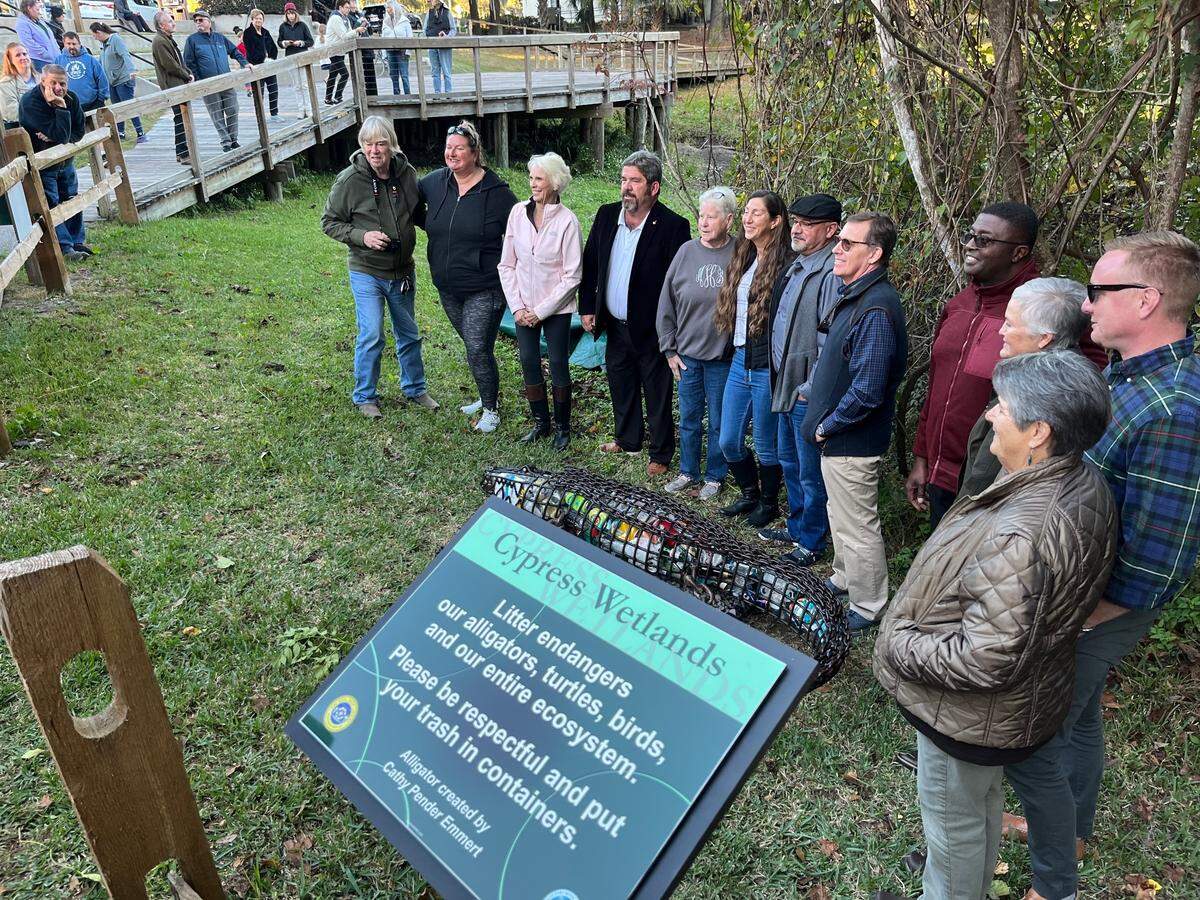 A sign has been erected near a metal art sculpture of an alligator filled with litter that reminds visitors to Cypress Wetlands in Port Royal how garbage can harm wildlife.
