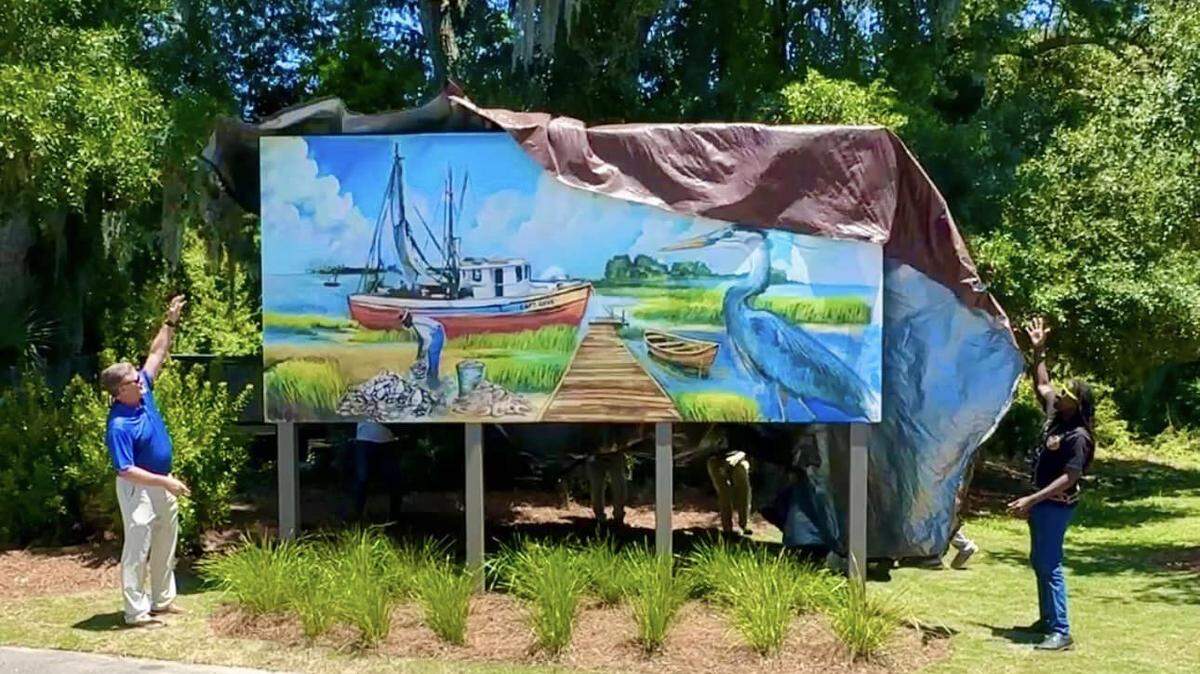 Hilton Head Island Mayor Alan Perry, left, and artist Amari Farris unveil a new mural at the town’s Rowing & Sailing Center at Squire Pope Community Park.