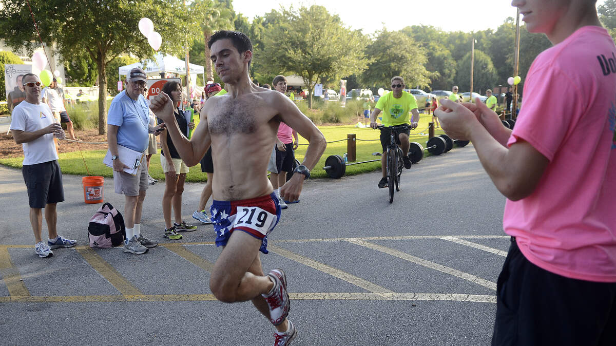Lee Cordova of Denver, Colo. crosses the finish line during the 7th Annual Run for RET 5K on Saturday morning at Hilton Head Prep on Hilton Head Island.  Cordova placed first in the 5K.