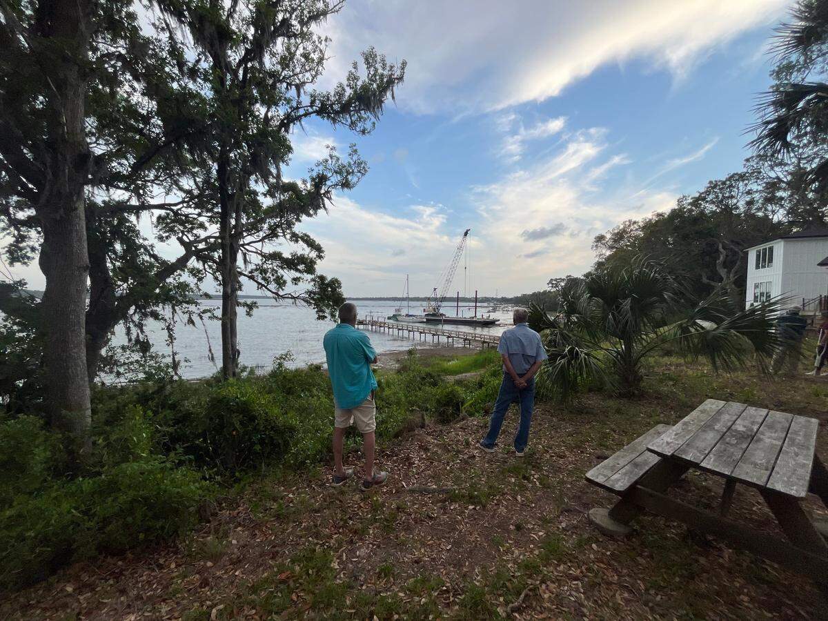 Beaufort residents watch the boat show Thursday evening when O’Quinn Marine was using a crane on a barge to lift sailboats beached by Tropical Storm Helene out of the Beaufort River shoreline.