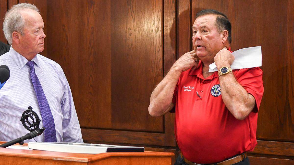 Beaufort County Coroner David Ott, right, demonstrates on Aug. 27, 2024 how Stanley Kotowski, 60, of Massachusetts reduced his airflow by strangulation in the crawlspace of a home in Sea Pines on Hilton Head Island at the Beaufort County Sheriff’s Office Headquarters as Beaufort County Sheriff PJ Tanner looks on.
