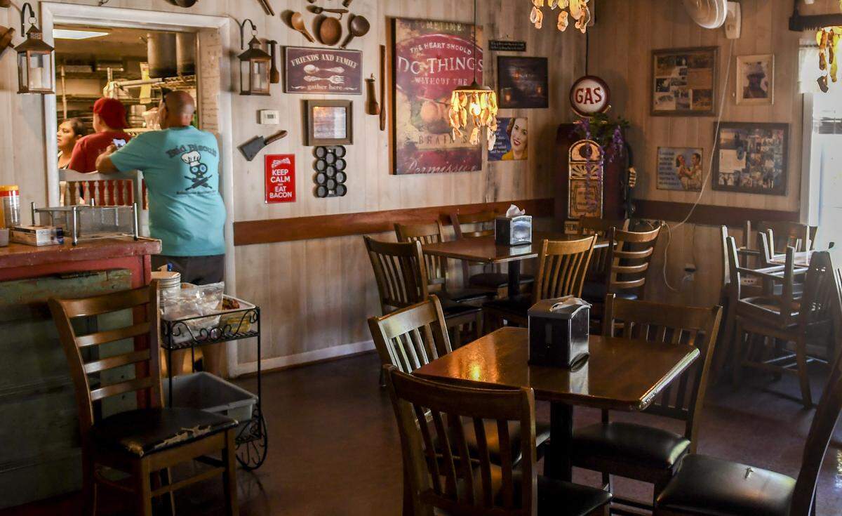 Dave Peck, owner of A Lowcountry Backyard Restaurant, talks to his kitchen staff on Monday, May 11, 2020 as properly spaced tables are ready for lunch guests on Hilton Head Island. Monday marked the first day restaurants could have indoor seating at half the capacity after SC Governor Henry McMaster relaxed some of the rules on closures he enacted to stop the spread of the coronavirus.  