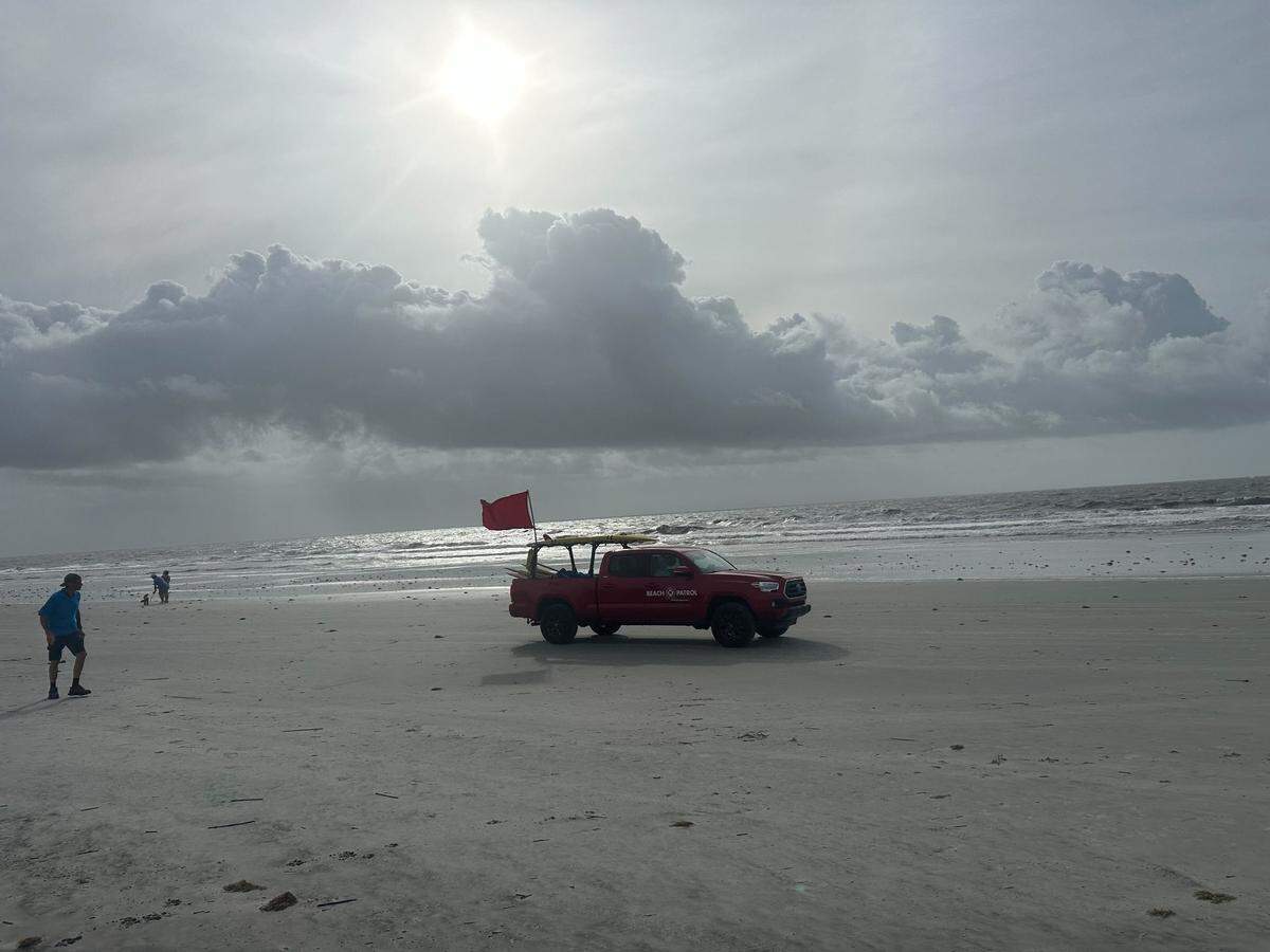 A beach patrol truck drives across Coligny Beach at 9:30 a.m. Friday flying a red flag, indicating a high risk of rip currents due to conditions from Helene. The system was downgraded to a tropical storm early Friday morning after it made landfall in Florida.