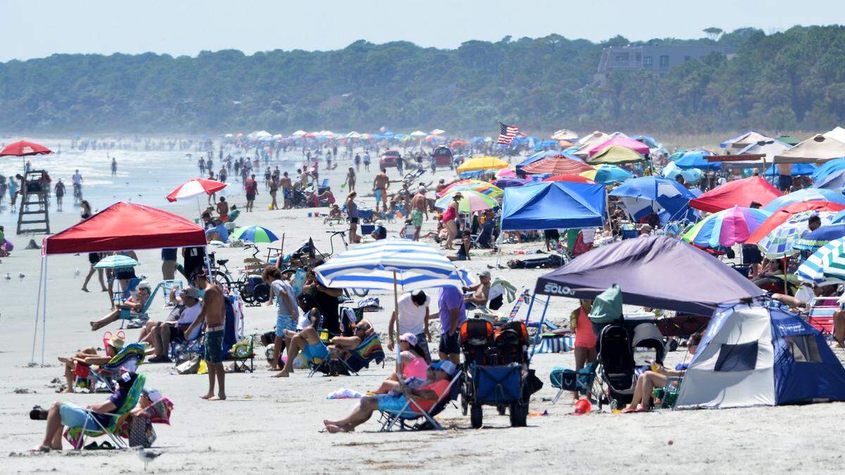 Beachgoers line the shore in this view looking down South Forest Beach toward Sea Pines on Hilton Head Island.