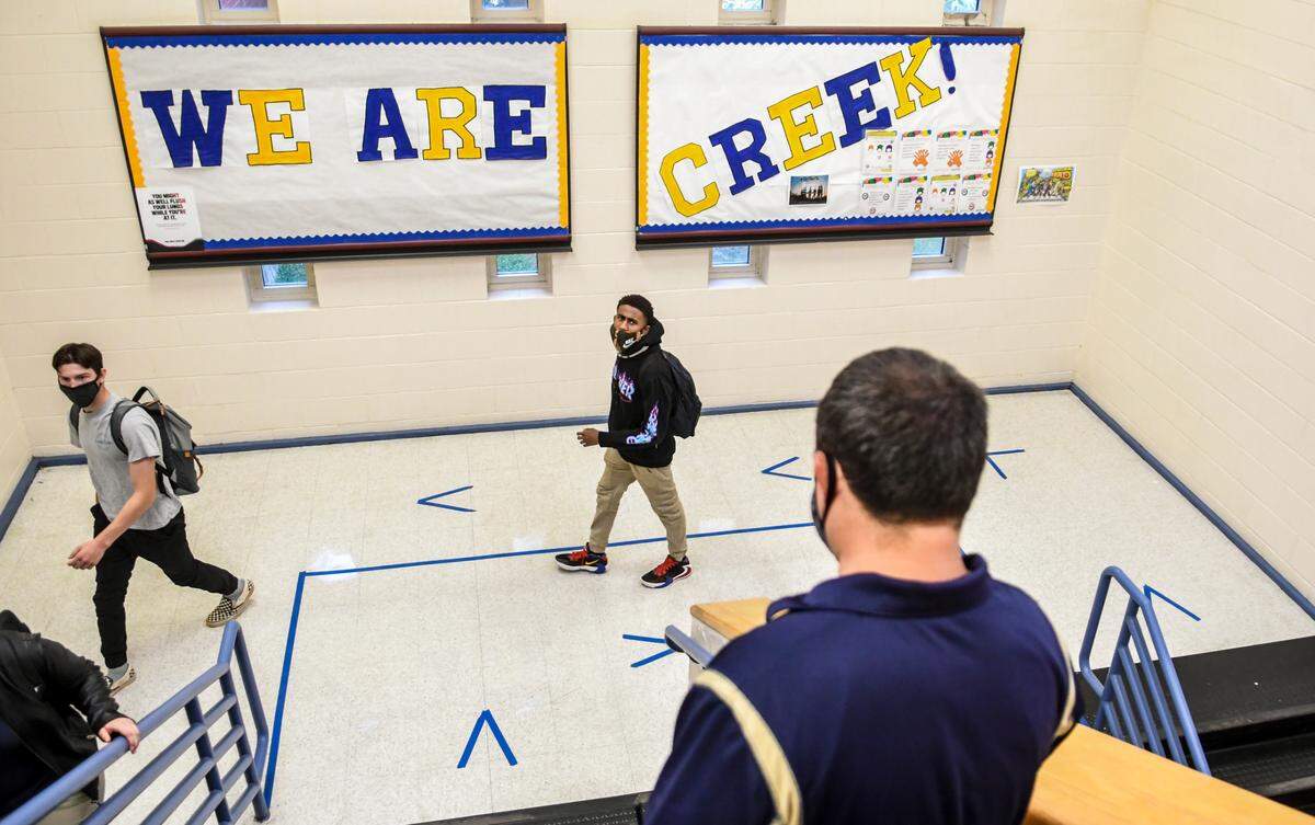 Battery Creek High School principal Chad Cox reminds students on Monday, Oct. 5. 2020 to keep distance betweed each other and follow the one-way directions in the stairwell. Cox said that a pre-pandemic student count would have placed about 800 students in the halls of Battery Creek. On Monday that figure was around 165 students. The Beaufort County School District is developing hybrid models of in-person instruction to keep staff and students safe from the spread of the coronavirus.