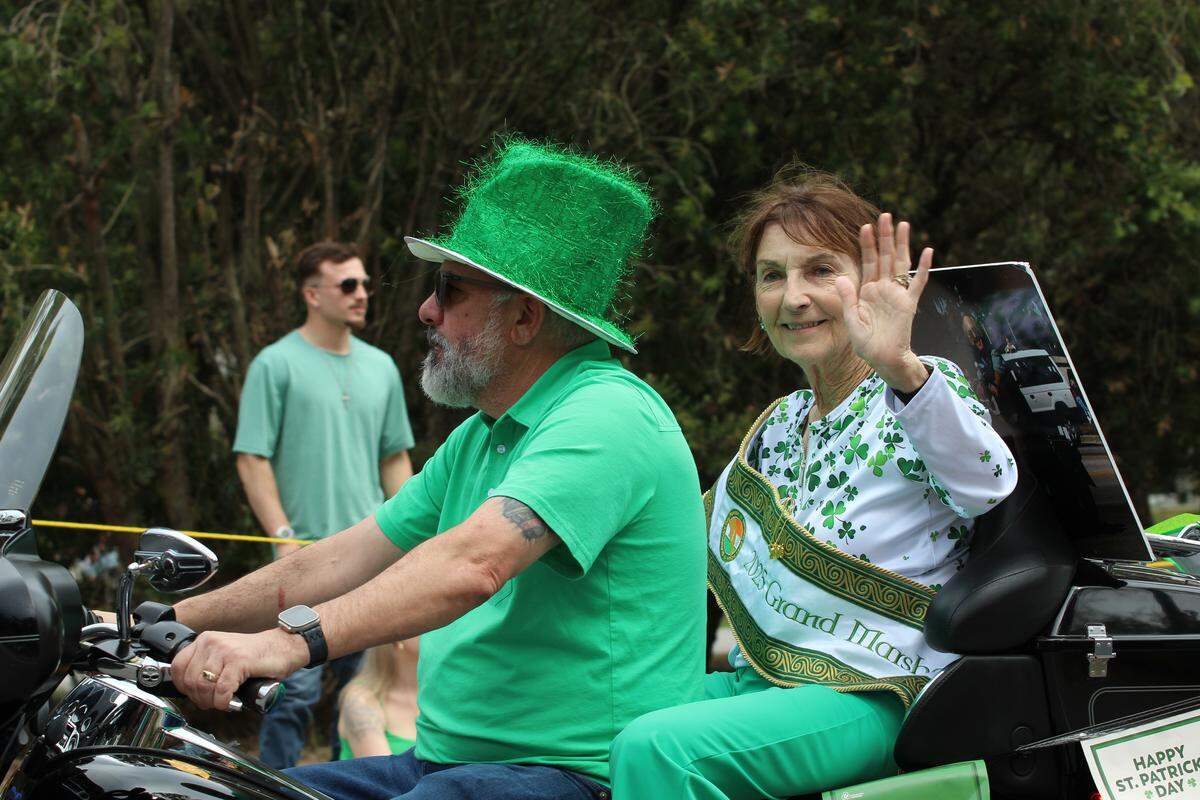 Diane Reilley, Grand Marshal of the 40th annual Hilton Head Island St. Patrick’s Day Parade, waves at spectators on March 15, 2026. Her husband, Tom Reilley, founded the parade more than 40 years ago. This year marks the first parade held since his death last May.