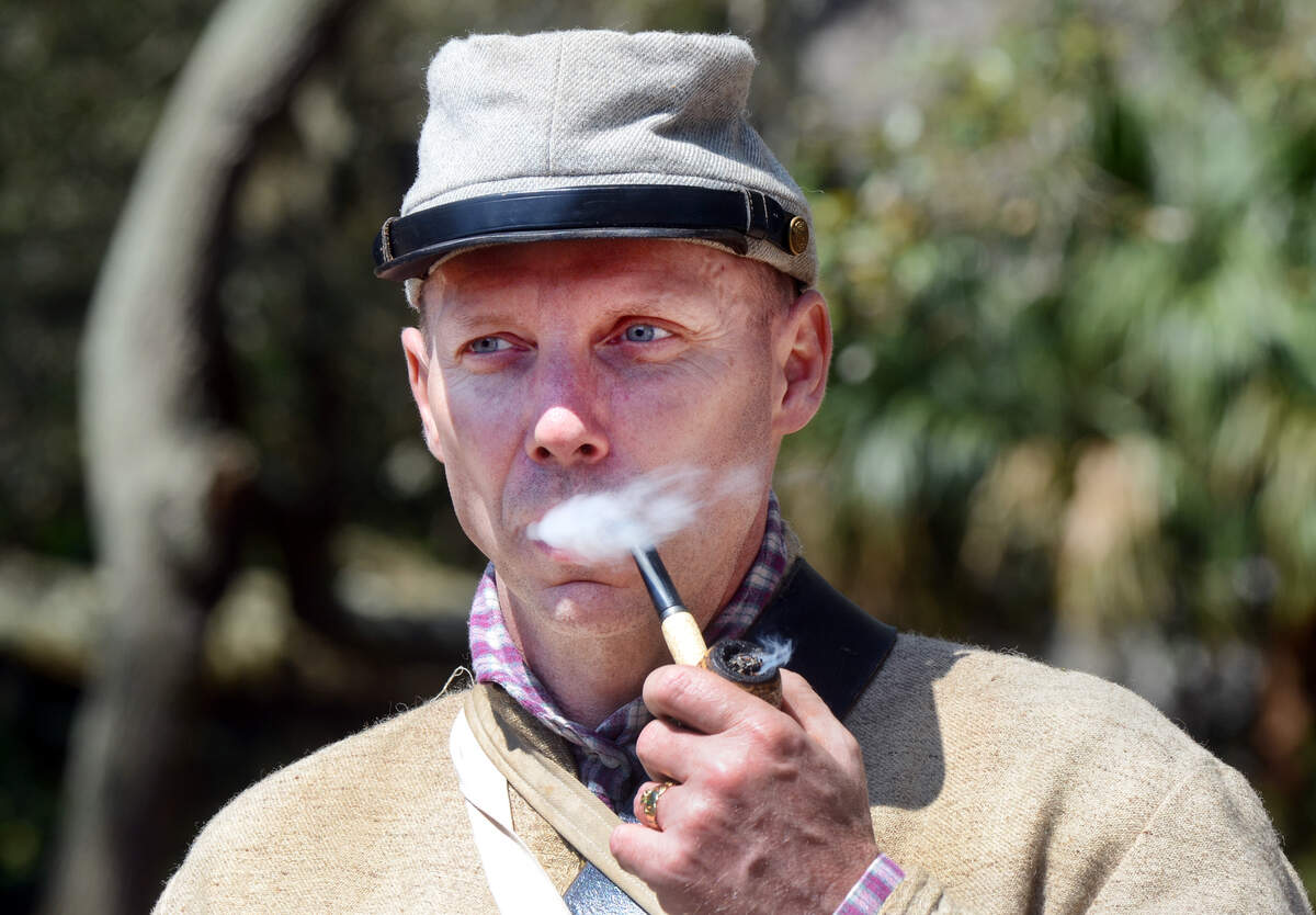 Civil War reenactor Vernon Edenfield, of Beaufort, takes a puff from his pipe during Hilton Head History Day on Saturday.