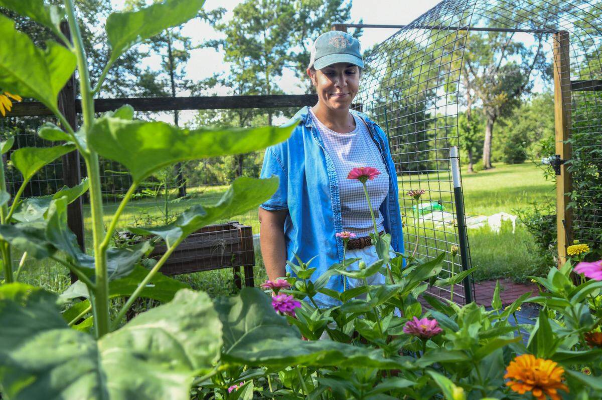 Chrissy Mozeleski, proprietor of Helena Hills Farm, stands in her garden among the flowers on July 14, 2025, in Hardeeville, S.C. The farm offers u-pick events as well as pressed-flower workshops where attendees can make floating candles, bookmarks and floral frames.