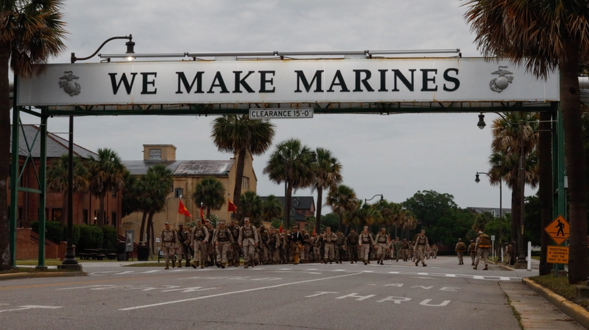 U.S. Marines with Hotel Company, 2nd Recruit Training Battalion, hike under the ‘We Make Marines” sign on Marine Corps Recruit Depot Parris Island, S.C., May 8, 2025.