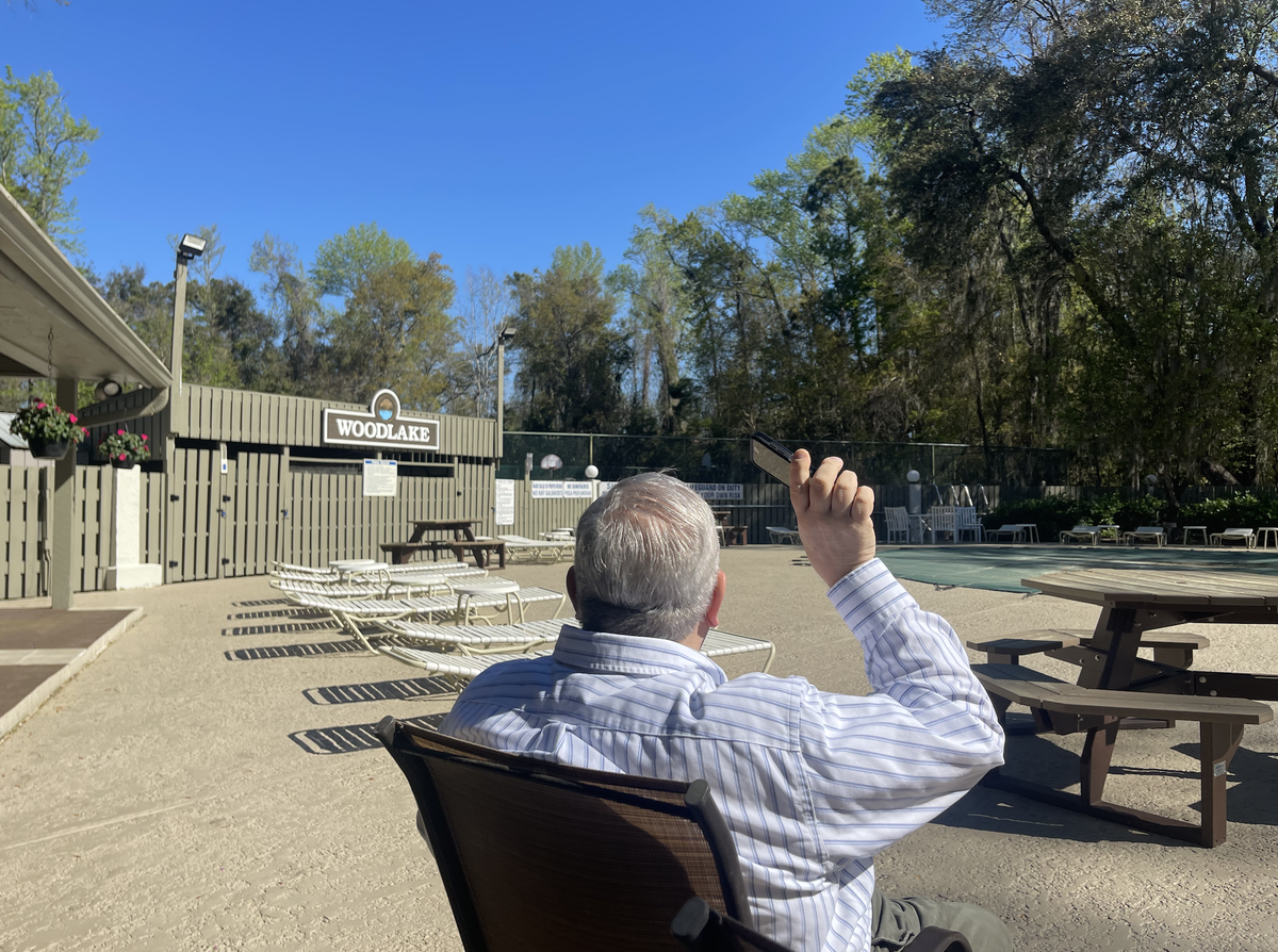 Robert “Bob” Arundell sits at Woodlake’s public pool, waiting for planes to fly by overhead. He has lived in the community for over 40 years.