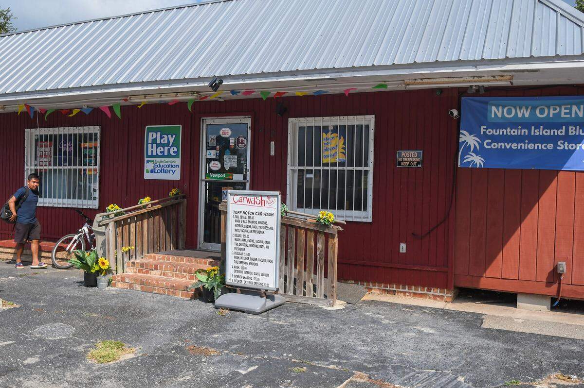 A customer dismounts their bike to shop at Fountain Island Blue Convenience Store on Wednesday, June 26, 2024 on St. Helena Island. Recently remodeled and under new management, the store offers a deli counter, lottery tickets, bait for fishing and a full-service car wash.