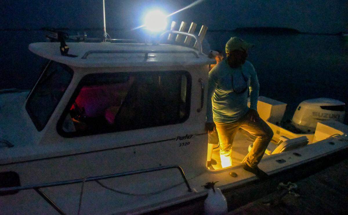 Nearly pitch black, Stewart Yarborough, owner of Daufuskie Adventures, makes sure his passengers have safely disembarked from Ashley Hollingsworth’s boat on Tuesday, Sept. 26, 2023, at Buckingham Landing on the mainland of Bluffton. Yarborough and his son Kade, captain the Daufuskie Island residents to the mainland every other week so the women can teach on Hilton Head Island. Formerly a contract enabled teachers to travel with students aboard the Haig Point Ferry between the islands.