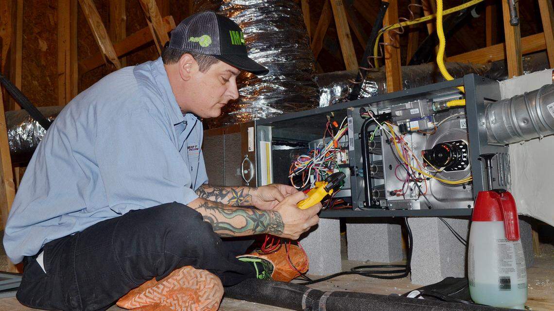 Jaysin Woodward, a technician with Covert Aire, performs a preventative maintenence check on a furnace in the attic of a Sun City home on Friday. Hilton Head area businesses are struggling to find workers for skilled labor positions, such as HVAC technicians.