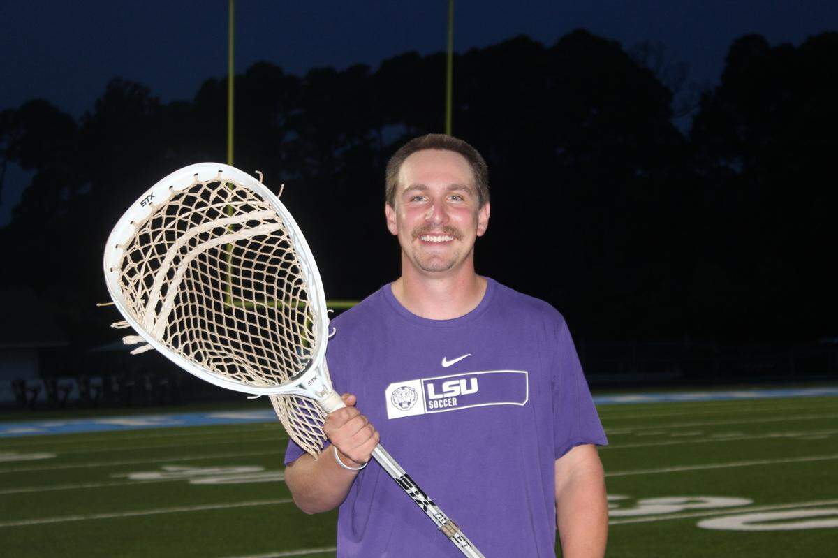 Hilton Head Island High School Coach Colin Courtney holds Joe Monmonier’s lacrosse stick. Monmonier, who was the school’s Athletic Director for 13 years, helped Courtney with his college applications when he was a student athlete at HHIHS.