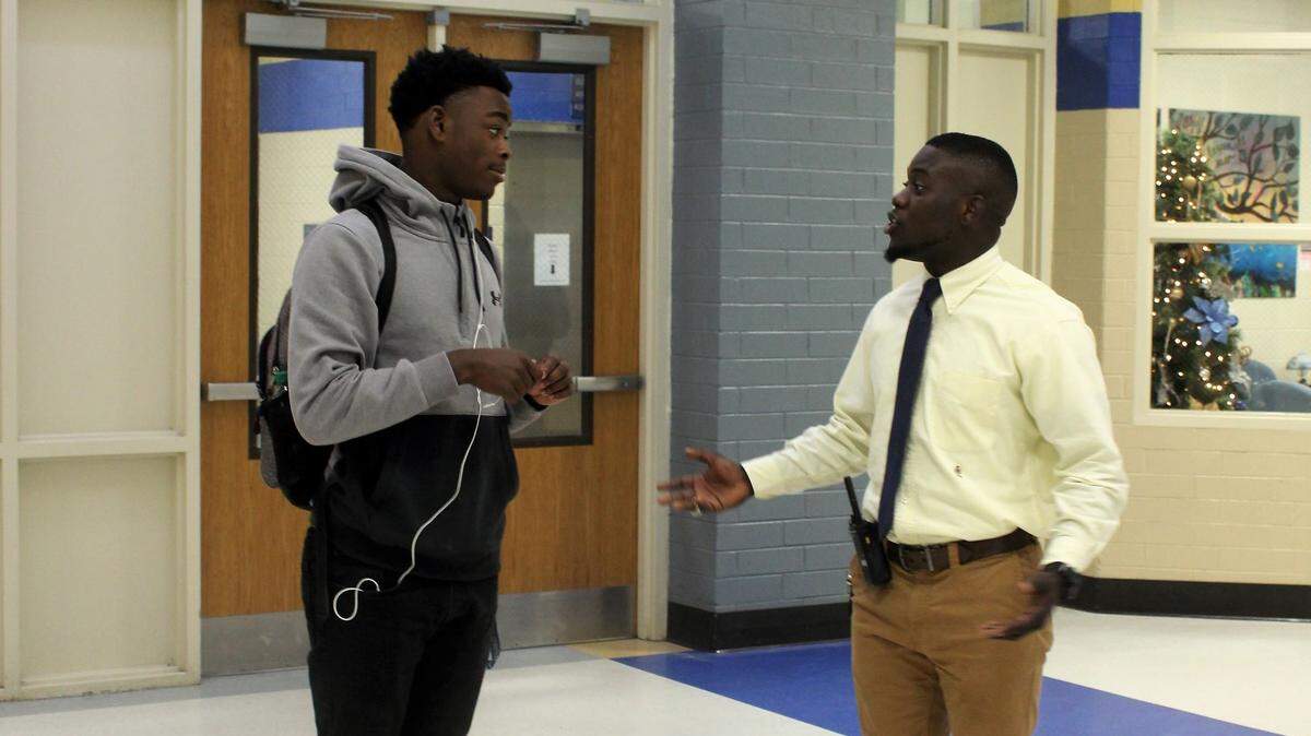 DeAndre Johnson, right, talks with a student at Battery Creek High School during class change.