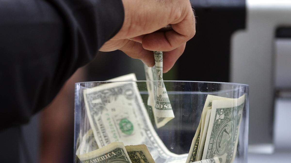 If the policy’s posted, businesses can add a tip to unclosed tabs. File photo - Money being put in to a tip jar at The Clubhouse Deck Bar at Harbour Town Golf Links in Sea Pines on Hilton Head Island S.C.