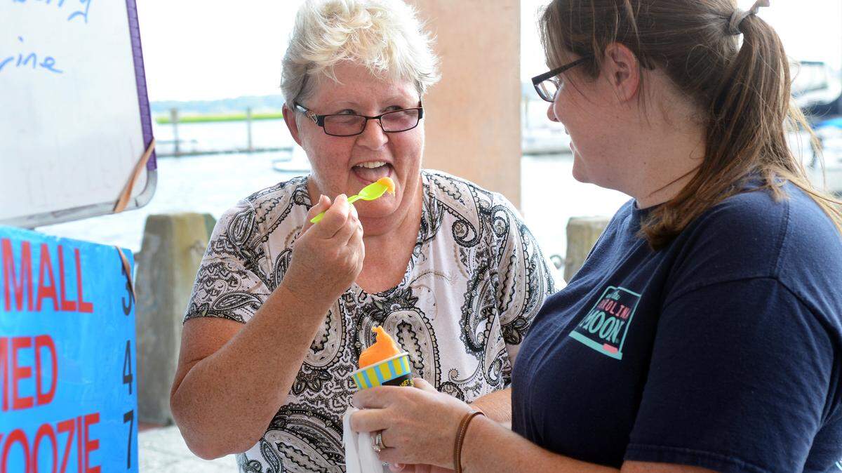 Beaufort Water Festival goers Karen Welker and her daughter Kristen Adams, both of Beaufort, were about to melt from the heat when they decided to stop and cool off with a creamsicle flavored treat at the Sunset Slush Classic Italian Ice cart along the promenade of the Henry C. Chambers Waterfront Park on Monday. "It is a hot afternoon," said Welker, with emphasis.