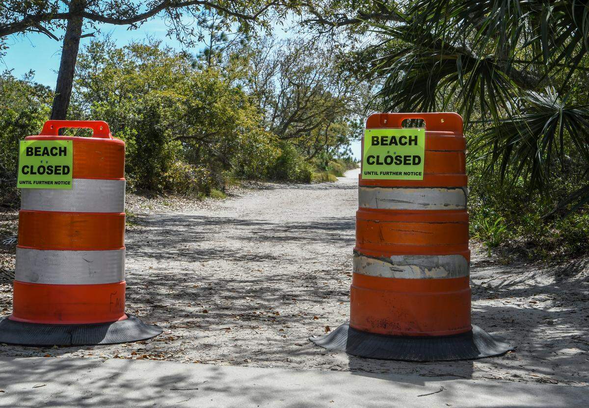 Signs posted at Burkes Beach by the Town of Hilton Head Island on construction traffic drums note that the beach is closed as seen on Thursday, March 26, 2020. Mayor John McCann closed the beaches in hopes of stemming the spread of the coronavirus sweeping the nation.