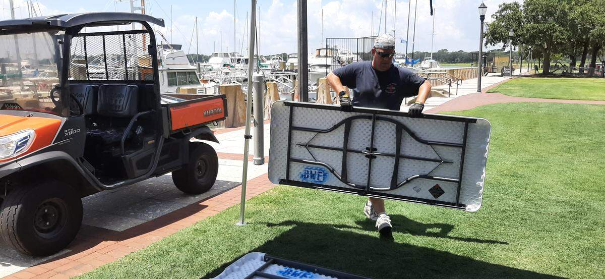 Volunteer Jason Barry unloads tables at a T-shirt stand Thursday for the Beaufort Water Festival, which begins Friday.