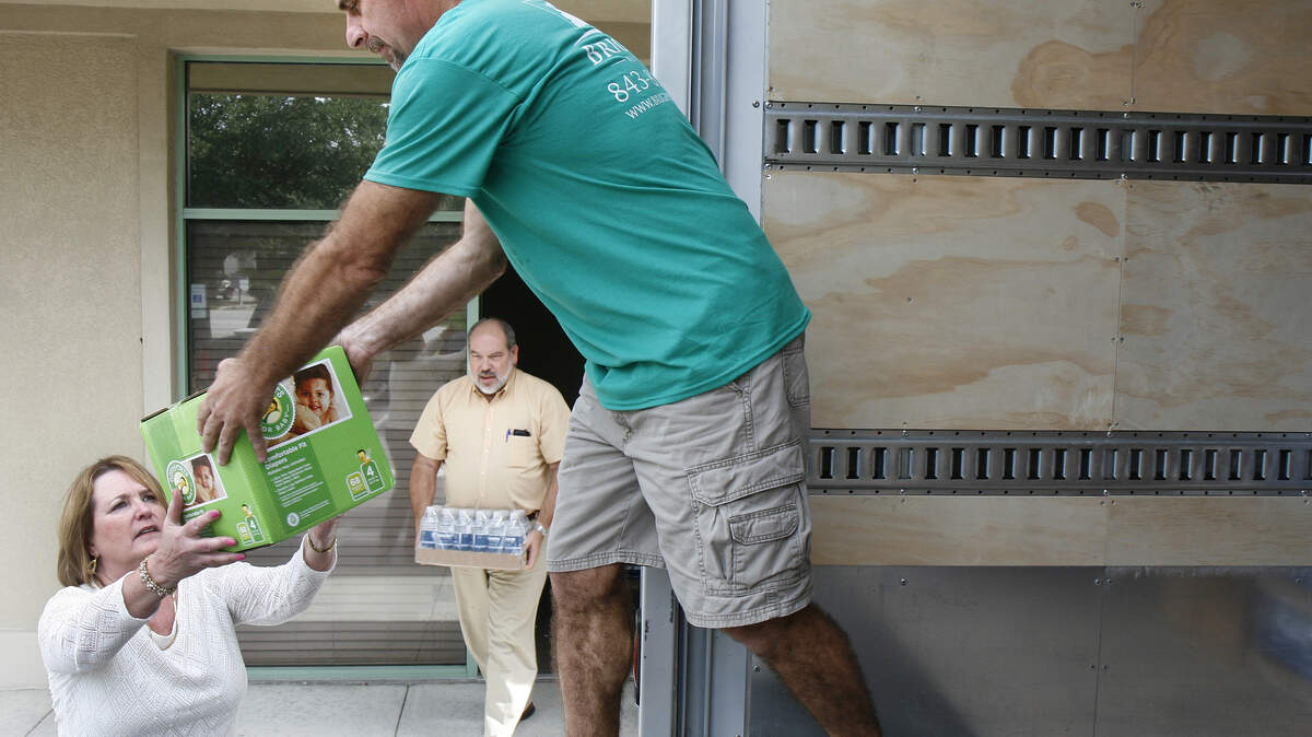 Susan Gonyou hands a box of diapers to Jerry Bauer, as John Hustedt carries a case of bottled water, to be loaded into a truck Friday, Oct. 9, 2015 at Bluffton?s Brighton Builders in Sheridan Park. Staff with the company were loading bedding, diapers, baby food and other essentials into a truck to be delivered this weekend to victims of the devastating floods in the Columbia, Charleston area. Gonyou, head of sales and marketing, says they are collecting donations at area schools to make another trip next week and are still accepting donations at their business located at 49 Pennington Drive, Suite B in Bluffton till Thursday. Some items that are being requested are: Baby diapers, baby wipes and formula; energy drinks, 100% juice and water; non-perishable food items; cleaning supplies; sheets, blankets, and pillows.