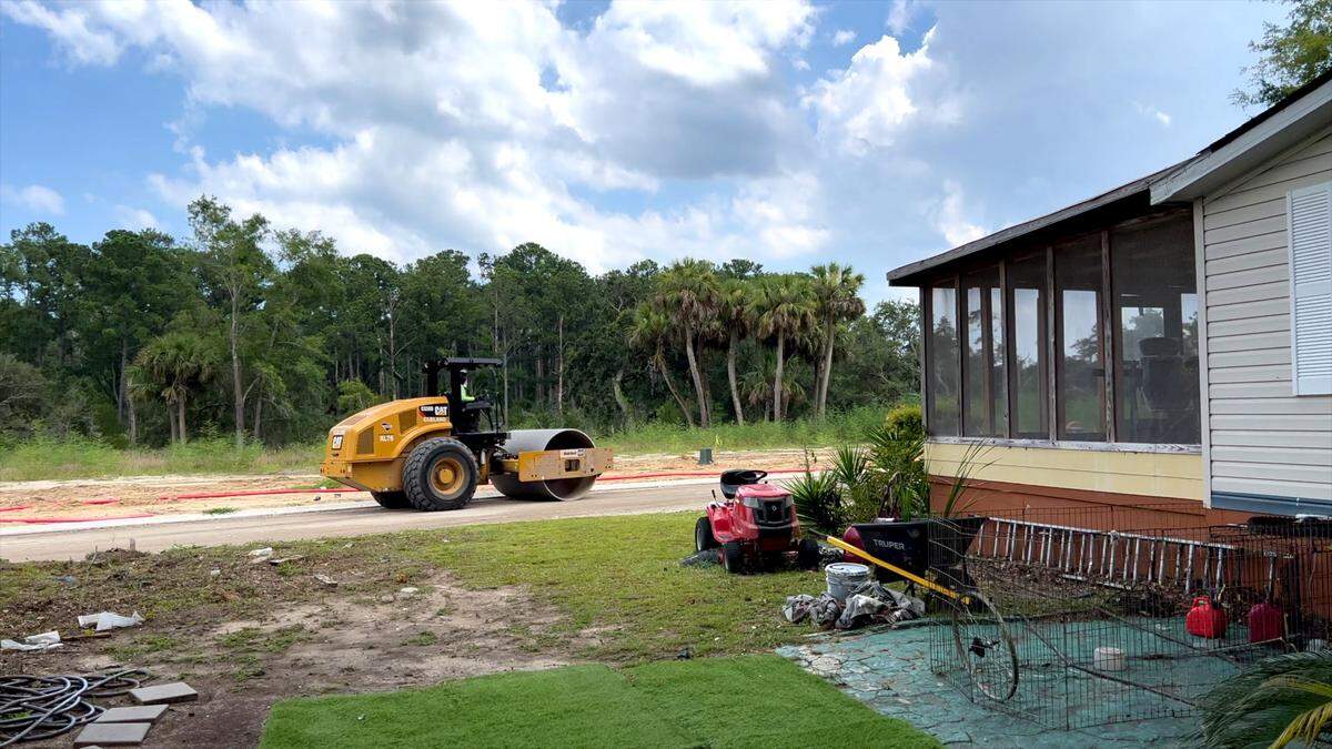 A road roller moves past the porch of Josephine Wright’s house. Wright is being sued by Bailey Point Investment LLC, which claims the screened porch in the photo is encroaching onto the land it is using to build 147 new homes. Drew Martin/Island Packet