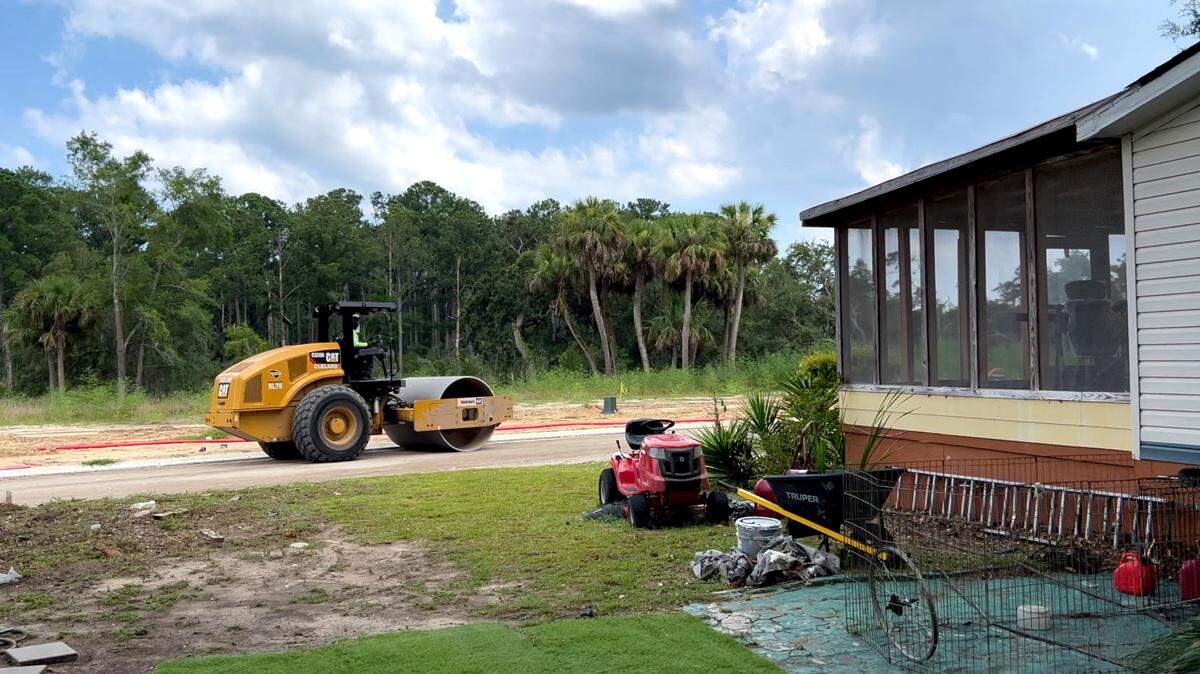 A road roller moves past the porch of Josephine Wright’s house. Wright is being sued by Bailey Point Investment LLC, which claims the screened porch in the photo is encroaching onto the land it is using to build 147 new homes. Drew Martin/Island Packet