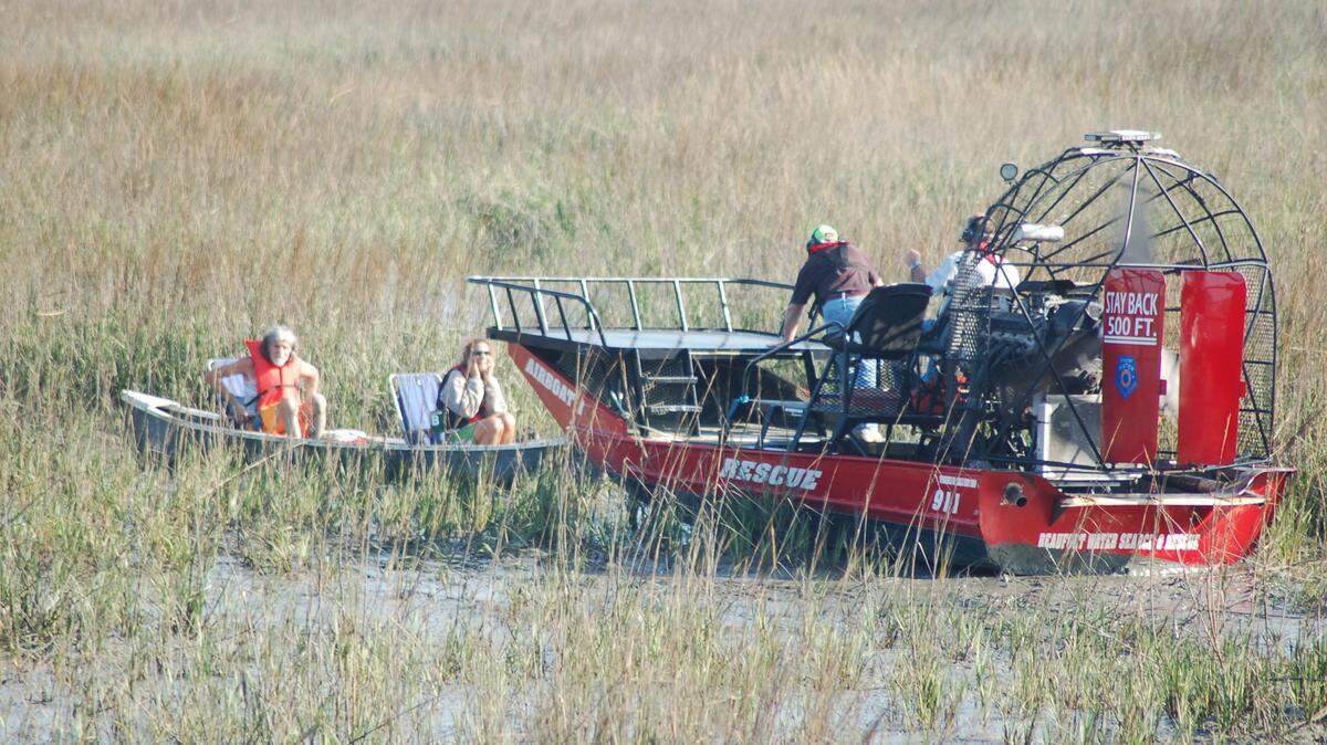 A photo taken by James Atkins shows two people being rescued by an airboat after being stranded in the marsh Friday near Pigeon Point in Beaufort.
