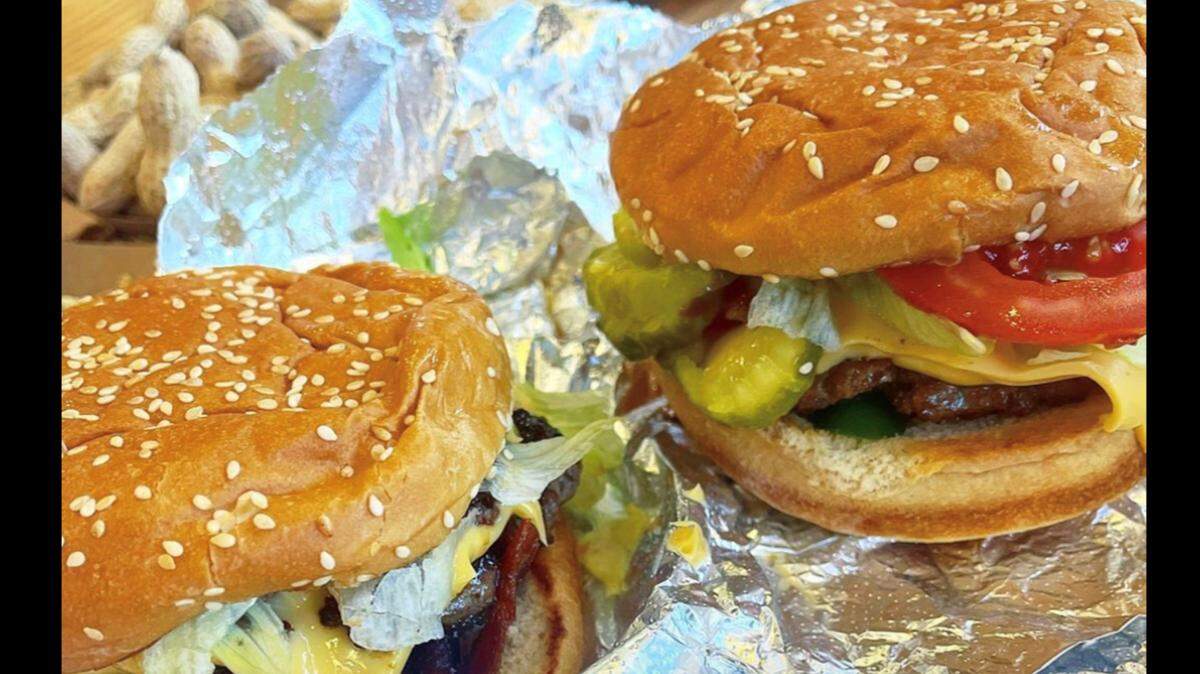 A Facebook post from Virginia-based burger chain Five Guys shows two cheeseburgers and a handful of complimentary peanuts in the background.