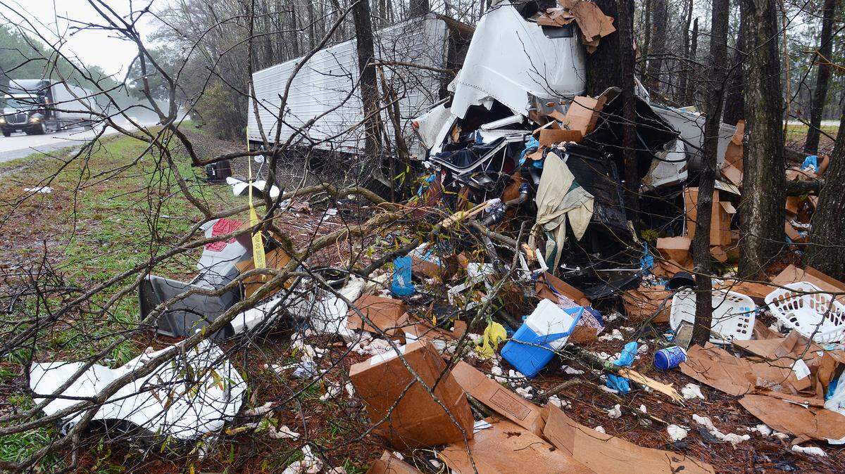 A wrecked tractor-trailer sits among the trees in the median of southbound I-95 on Feb. 4. The truck, hauling chicken meat that was strewn about the accident site, crashed near mile marker 13 in Jasper County.