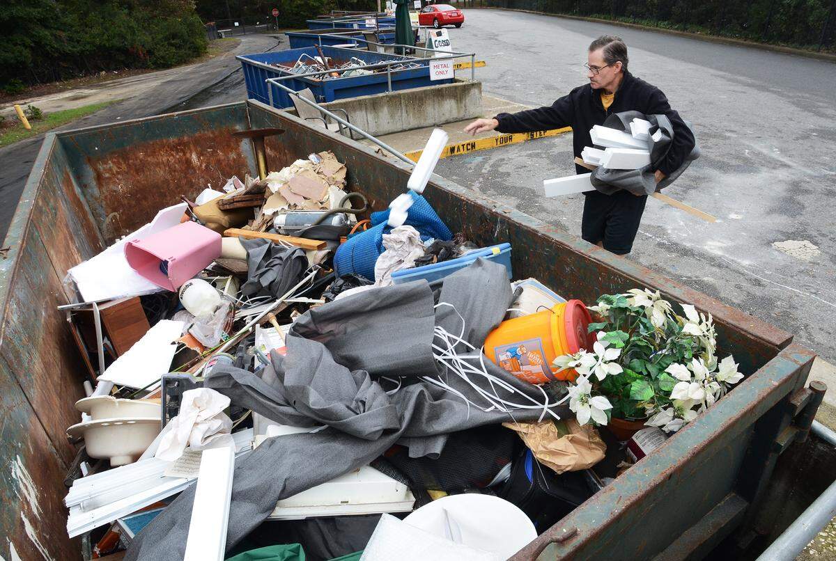 Hilton Head Islander Jaime Palatucci drops off some trash into an almost full bin at the island waste transfer station on Thursday. The bin had been empty three or four hours prior, said employee James Fox. Some people have been complaining about overflowing bins at the county-operated center recently.