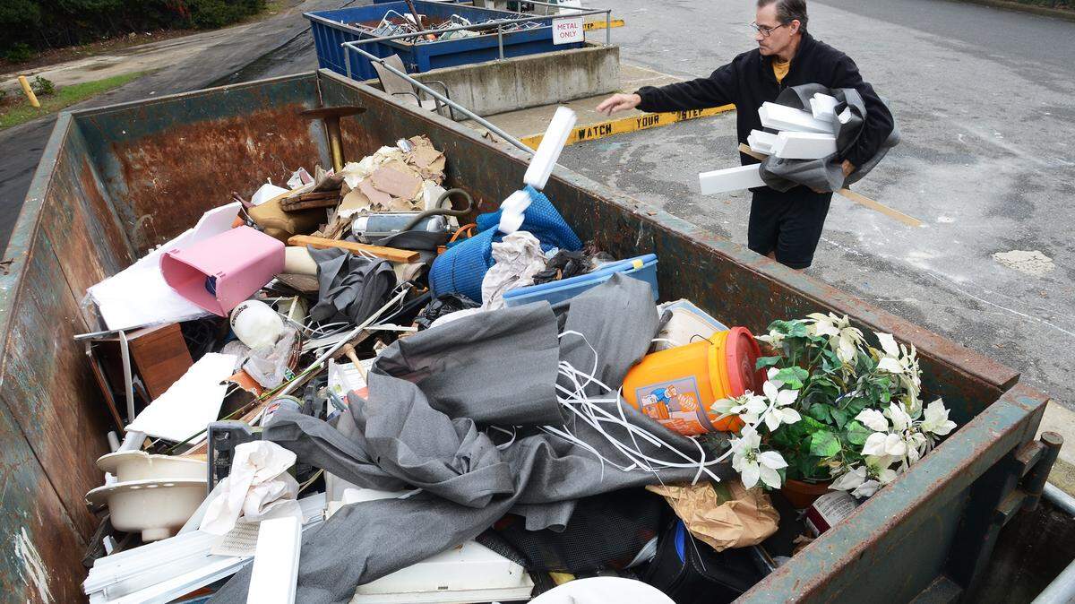 Hilton Head Islander Jaime Palatucci drops off some trash into an almost full bin at the island waste transfer station on Thursday. The bin had been empty three or four hours prior, said employee James Fox. Some people have been complaining about overflowing bins at the county-operated center recently.