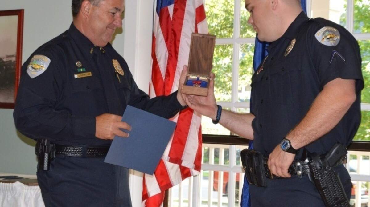 Bluffton Police Chief Joey Reynolds, left, recently awarded Officer Brady Lee the Life-Saving Award and Officer of the Year Award. On Nov. 25, Lee -- along with an area firefighter -- jumped into a drainage pond along Buckwalter Parkway to rescue the driver of a submerged truck.