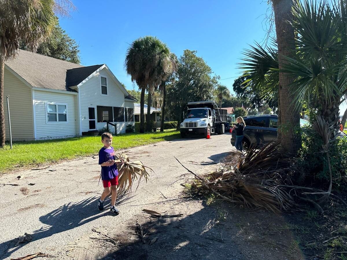 8-year-old Harrison McKenzie helped pick up nearby palmetto fronds along Alljoy Road and the “Chisholm Cottage.” Some of the fallen debris was larger than himself.